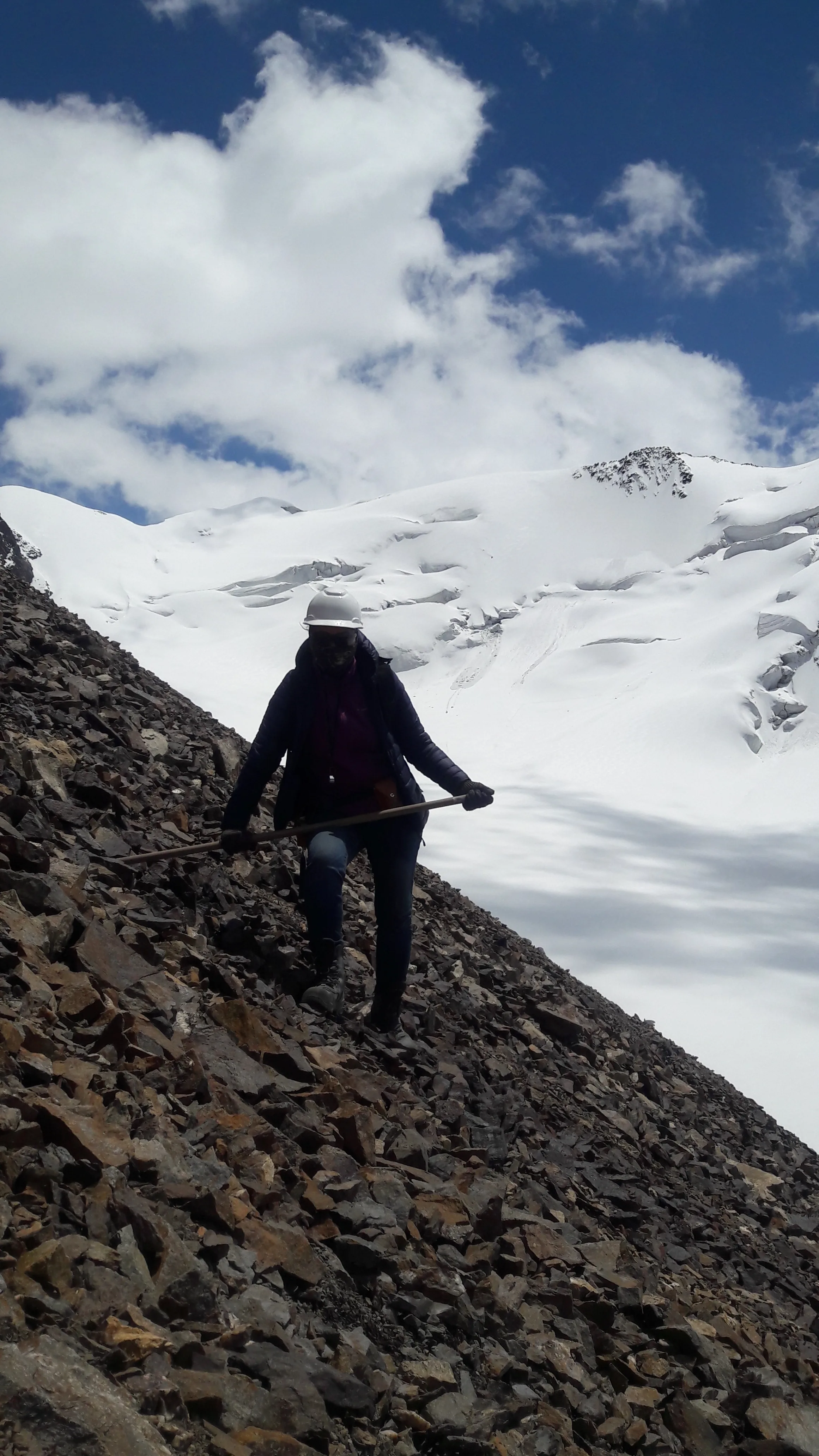Geologist traversing a scree slope during field mapping